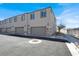 Modern townhome exterior featuring a garage, neutral stucco, and landscaped surroundings under a blue sky at 5609 Steampunk St, Las Vegas, NV 89118