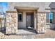 Inviting front entrance featuring stone pillars and a neutral-colored door, creating a warm and stylish welcome at 5609 Steampunk St, Las Vegas, NV 89118