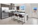 Modern kitchen featuring stainless steel appliances, dark wood cabinets, and a breakfast bar with seating at 5609 Steampunk St, Las Vegas, NV 89118
