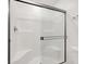 Modern walk-in shower with a glass door, tiled walls, and a built-in seat for a luxurious bathing experience at 5609 Steampunk St, Las Vegas, NV 89118