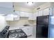 Bright kitchen featuring white cabinets, solid surface countertops, and black appliances at 605 S Royal Crest Cir # 20, Las Vegas, NV 89169