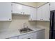 Galley kitchen featuring white cabinets, marble countertop, and stainless steel sink at 605 S Royal Crest Cir # 20, Las Vegas, NV 89169