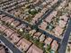 A high-angle aerial view shows homes in a desert community, many with private pools at 6148 Whitelion Walk St, Las Vegas, NV 89148