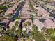 Aerial view of a neighborhood with desert landscaping, palm trees, and community pools at 6148 Whitelion Walk St, Las Vegas, NV 89148