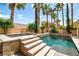 Tranquil backyard featuring a shimmering pool, elevated spa, and lush greenery, creating a peaceful outdoor escape at 6148 Whitelion Walk St, Las Vegas, NV 89148