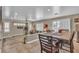 Open-concept dining area featuring a wooden table with chairs, blending into a sunlit living space at 6148 Whitelion Walk St, Las Vegas, NV 89148