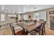 Open-concept dining area featuring a wooden table with chairs, blending into a sunlit living space at 6148 Whitelion Walk St, Las Vegas, NV 89148