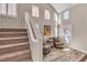 Welcoming foyer with staircase, large windows, and seating area with two accent chairs at 6148 Whitelion Walk St, Las Vegas, NV 89148