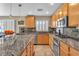 Traditional kitchen featuring granite countertops, stainless steel appliances, tile backsplash and light wood cabinets at 6148 Whitelion Walk St, Las Vegas, NV 89148