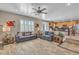 Spacious living room featuring tile floors, a ceiling fan and comfortable couches with throw pillows at 6148 Whitelion Walk St, Las Vegas, NV 89148