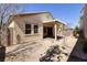 The backyard features a patio with a cover, desert landscaping, and the back of the home at 677 Viale Machiavelli Ln, Henderson, NV 89011