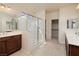 Bright bathroom featuring double sinks, a shower with glass doors, and a large walk-in closet at 677 Viale Machiavelli Ln, Henderson, NV 89011