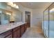 Bathroom featuring double sinks and a glass shower door, as well as a large mirror at 677 Viale Machiavelli Ln, Henderson, NV 89011