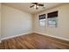 Bright bedroom featuring wood floors, two windows with blinds, and a ceiling fan with light at 677 Viale Machiavelli Ln, Henderson, NV 89011