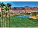 Picturesque golf course with lush green fairways, a pond, and mountain views at 677 Viale Machiavelli Ln, Henderson, NV 89011