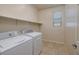 Functional laundry room with a washer, dryer, storage shelf, and window to let light in at 677 Viale Machiavelli Ln, Henderson, NV 89011