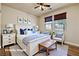 Comfortable main bedroom with neutral decor, two windows, and an accent bench at 677 Viale Machiavelli Ln, Henderson, NV 89011