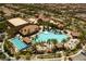 Aerial view of community pool with lounge chairs, palm trees, cabanas, and meticulously maintained landscaping at 677 Viale Machiavelli Ln, Henderson, NV 89011