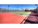 Community tennis court with green and red surface, fenced for recreational enjoyment at 677 Viale Machiavelli Ln, Henderson, NV 89011