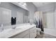 Well-lit bathroom features a wide mirror, white vanity, and shower-tub combo at 6773 Bristle Falls St, Las Vegas, NV 89149