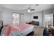 Spacious primary bedroom features a ceiling fan, television and barn door access to the ensuite bathroom at 6773 Bristle Falls St, Las Vegas, NV 89149