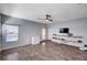 Spacious living room boasting wood floors, ceiling fan, floating shelves, and backyard access at 6773 Bristle Falls St, Las Vegas, NV 89149