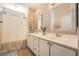 Traditional bathroom featuring double sinks, white cabinetry, framed mirrors and shower with curtain at 7633 Alexander Hills St, Las Vegas, NV 89139
