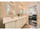 Traditional bathroom featuring double sinks, white cabinetry, framed mirrors and connecting bedroom at 7633 Alexander Hills St, Las Vegas, NV 89139