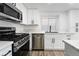 Modern kitchen features stainless steel appliances, updated countertops, and sleek white cabinetry at 80 Sea Holly Way, Henderson, NV 89074