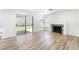 Bright living room with wood-look flooring, fireplace, and sliding glass door to the backyard at 80 Sea Holly Way, Henderson, NV 89074