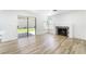 Bright living room with wood-look flooring, fireplace, and sliding glass door to the backyard at 80 Sea Holly Way, Henderson, NV 89074