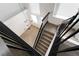 Staircase with black railings and a modern chandelier, providing stylish transition between floors at 80 Sea Holly Way, Henderson, NV 89074
