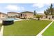 Landscaped backyard featuring artificial turf, an inground pool, and lounging area at 8369 Eagle Estates Ct, Las Vegas, NV 89131