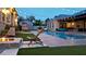 Outdoor oasis featuring a pool, fire pit, string lights, and lush artificial turf at 8369 Eagle Estates Ct, Las Vegas, NV 89131