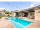 Large backyard with a pool, spa, covered patio, outdoor kitchen, solar panels and lounge chairs at 8369 Eagle Estates Ct, Las Vegas, NV 89131