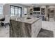 Kitchen island with counter seating and view of the modern fireplace at 8369 Eagle Estates Ct, Las Vegas, NV 89131