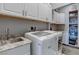 Well-organized laundry room with white cabinets, granite counters, and modern washer/dryer at 8369 Eagle Estates Ct, Las Vegas, NV 89131