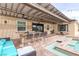 Outdoor kitchen and bar seating with built-in grill and a partially covered patio with ample seating at 8369 Eagle Estates Ct, Las Vegas, NV 89131