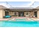 Resort-style pool with a hot tub, outdoor kitchen, and partially covered patio, perfect for outdoor living at 8369 Eagle Estates Ct, Las Vegas, NV 89131