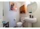 This half-bath features stylish decor, pedestal sink with modern faucet, and a comfort height toilet at 9105 Captivating Ave, Las Vegas, NV 89149