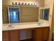 Bathroom featuring double sinks, wood cabinets, and modern fixtures at 9303 Gilcrease Ave # 2164, Las Vegas, NV 89149