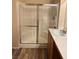 Modern bathroom with a glass-enclosed shower, wood cabinets, and countertop sink at 9303 Gilcrease Ave # 2164, Las Vegas, NV 89149