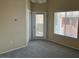 Neutral-toned room featuring plush carpeting, natural light, and a door to the outside at 9303 Gilcrease Ave # 2164, Las Vegas, NV 89149