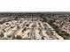 A high-angle view of a neighborhood filled with uniform single-Gathering houses, landscaping, and a distant cityscape at 9625 Beach Water Cir, Las Vegas, NV 89117