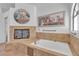 Bathroom showcasing a large bathtub and glass-enclosed fireplace at 9625 Beach Water Cir, Las Vegas, NV 89117
