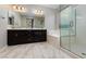Modern bathroom with dual vanities, a separate tub, and a glass-enclosed shower at 1015 Solana Crest St, Henderson, NV 89052