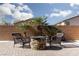 Outdoor patio featuring a stone fire pit, comfortable seating, and lush tropical landscaping at 1015 Solana Crest St, Henderson, NV 89052