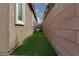 Narrow side yard featuring artificial turf, offering a low-maintenance outdoor space at 1015 Solana Crest St, Henderson, NV 89052
