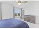 Bedroom featuring carpet floors, a ceiling fan, and a dresser with decor, and large window at 10165 Canyon Mantle St, Las Vegas, NV 89166