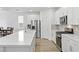 A kitchen showcases stainless steel appliances, white cabinets, tile backsplash, and a long island with sink at 10165 Canyon Mantle St, Las Vegas, NV 89166